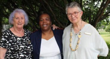 Three women embracing each other