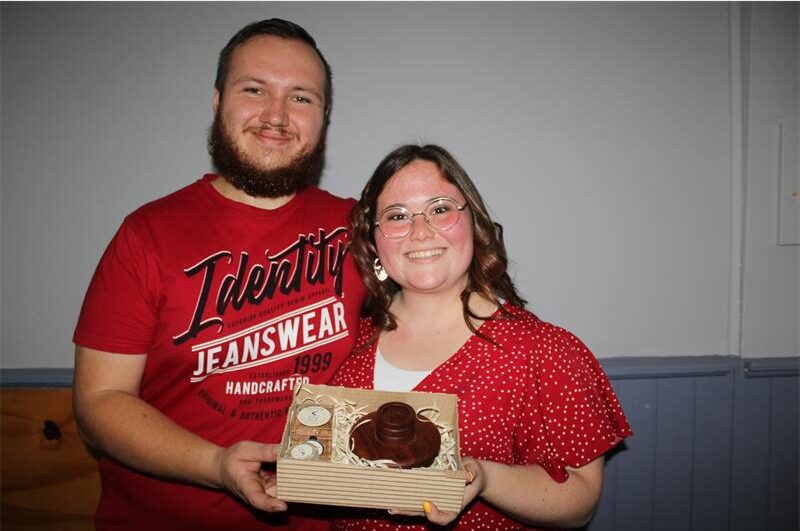 Man and woman dressed in red holding a box