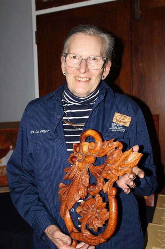 Older woman holding a wooden sculpture