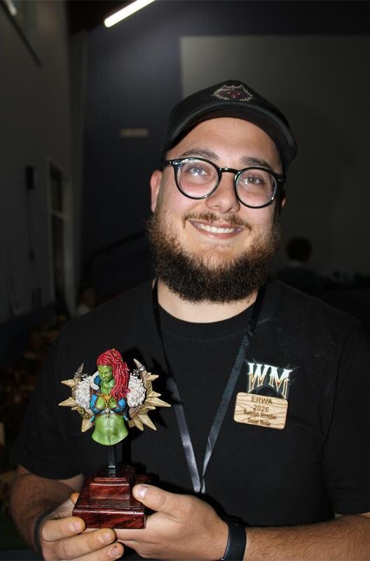 Man wearing glasses holding a statue