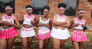 Girls wearing zulu attire in pink and white.