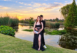 Young man and girl in evening wear pose in front of a dam at sunset