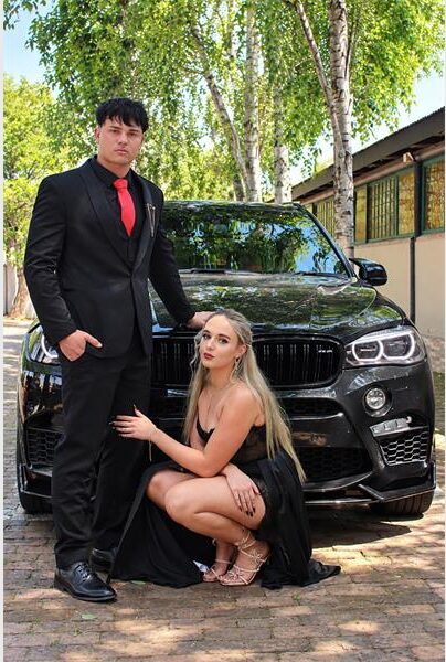 Young man and girl standing at a black car