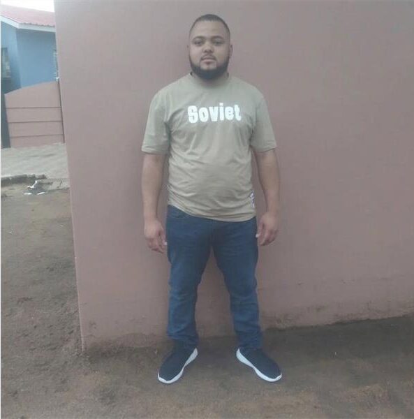 Coloured man standing against a wall