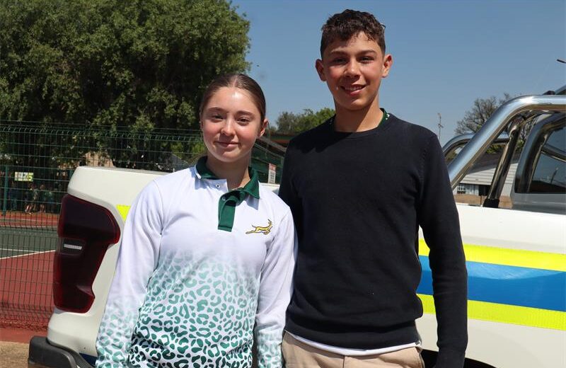 A girl wearing a white jersey and a boy wearing black jersey.