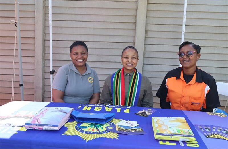Three ladies seated by the SAPS table