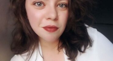 A lady with a red lipstick and a white shirt