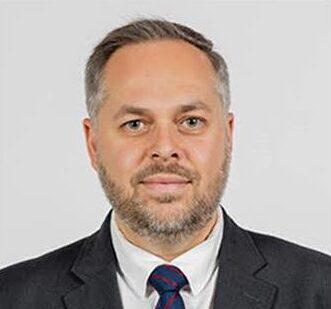 A man in a black suit and a blue tie.