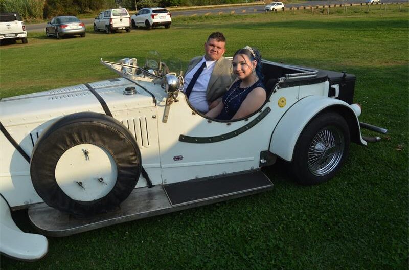 Young man and girl sitting in an antique car
