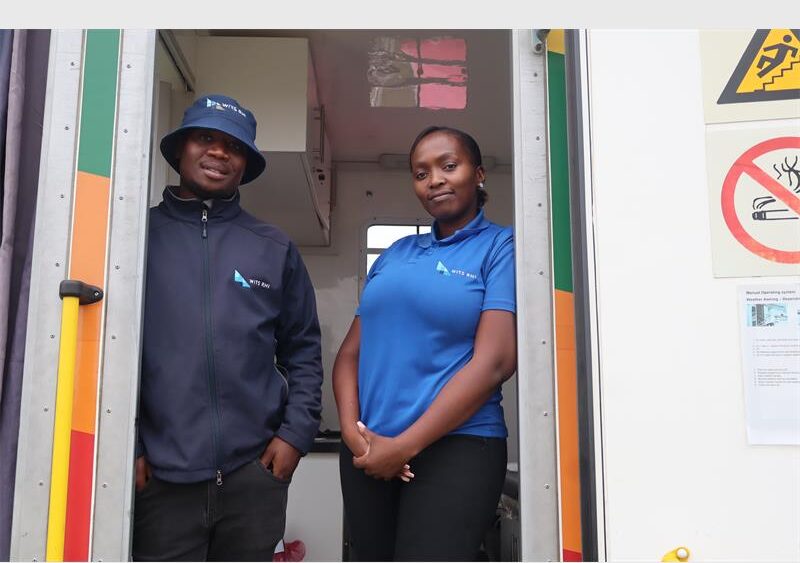 A man and a lady standing in a truck