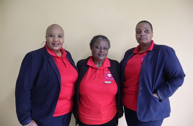 Ladies wearing red tops and blue jacket.