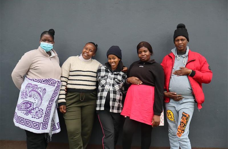 Pregnant women standing next to each other