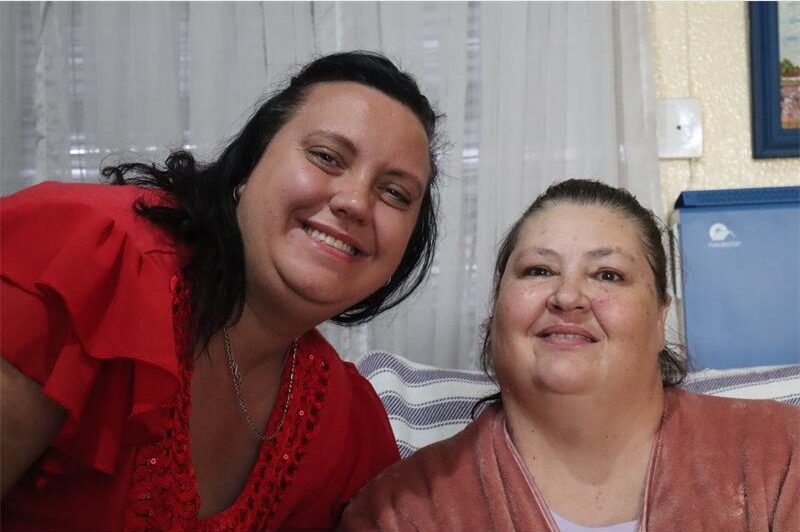One lady wearing red and the other wearing pink