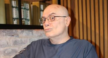 Elderly man wearing glasees poses making a duck face