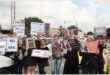 A group of people standing with placards outside a court building.