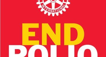 Red poster with the Rotary International logo with the words end polio now
