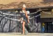 Black girl walking on a stage with a dress made of black bags
