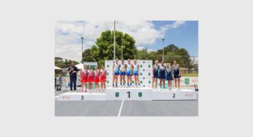 Teams of tennis players standing on a podium.