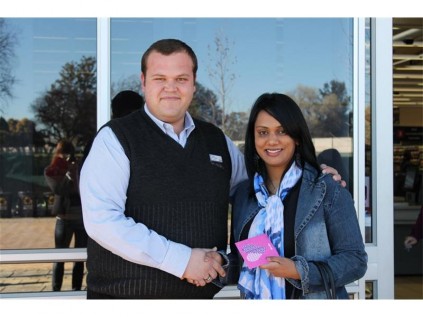 Pick n Pay Brentwood Park store manager Shaun Matthee hands over a shopping voucher from Pick n Pay, valued at R1 000, to Pamentha Govender, now Kadathlal, May Bride of the Year entrant.