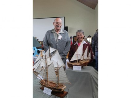Frank and Beulah Albrecht with their team effort: wooden ships, Frank builds the ships and Beulah sews the sails for them.