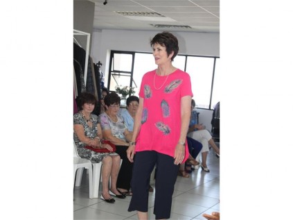 A model wears a beautiful bright blouse with complementing navy blue trousers.