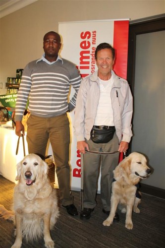 The South African Guide Dogs Association's Alson Maphosa (left) and guide dog O'Reilly, who has been in service for six years. He is seen with Jan de Waal and Tommy, a puppy-in-training with the South African Guide Dogs Association.