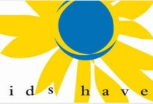 Yellow flower with blue dot and words Kids Haven