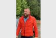 Man with a beard wearing an orange puffer jacket