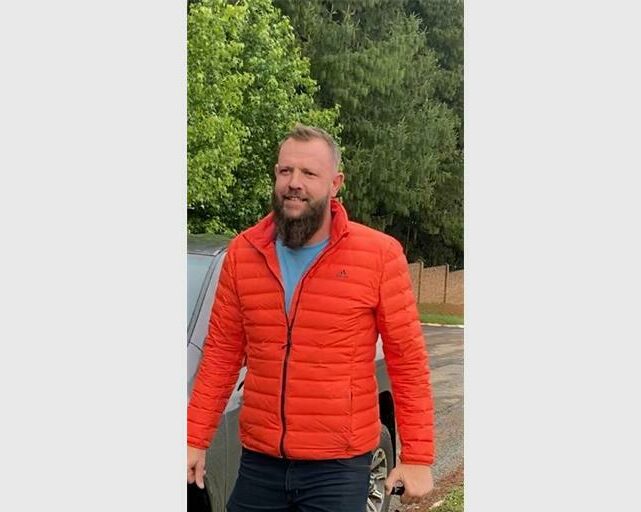 Man with a beard wearing an orange puffer jacket