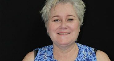 Blonde woman against a black back ground