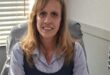 White woman sitting behind a desk
