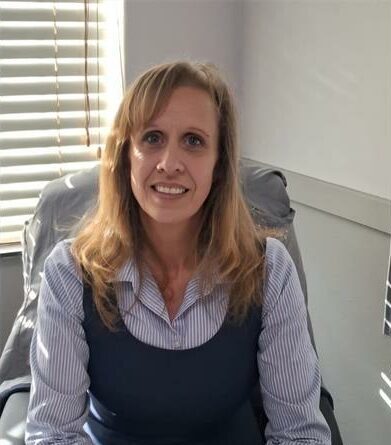 White woman sitting behind a desk