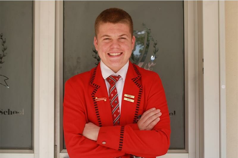 Rugby player Clayton Kewley is pictured wearing a red blazer, white shirt and tie.