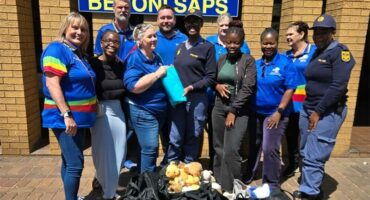 Photo of DA members in front of the Benoni Police Station with dignity packs by their feet.