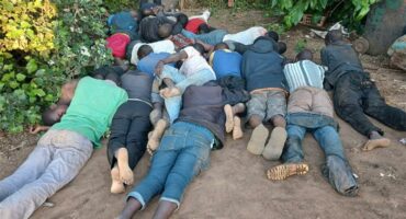 Photo of alleged illegal immigrants lying face down on the ground.