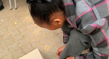 Photo of a young girl putting on new school shoes.