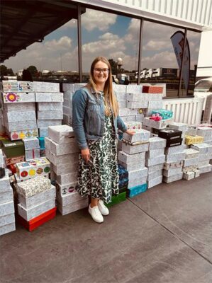 Photo of St Dunstan’s College’s head of service, Sarah Bouch outside the Santa Shoebox Project’s warehouse facility in 2024.