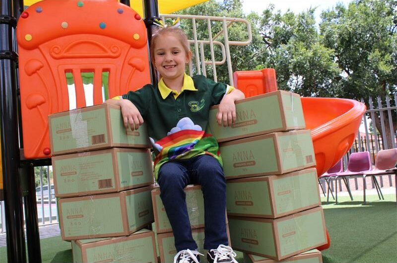 Dogtertjie met ‘n groen hempie sit op bokse