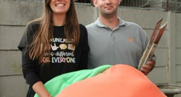 Woman with long dark hair with a man wearing a grey shirt.
