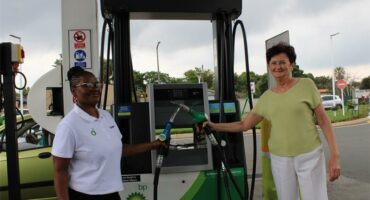 A black woman and a white woman standing at petrol pump with the BP logo