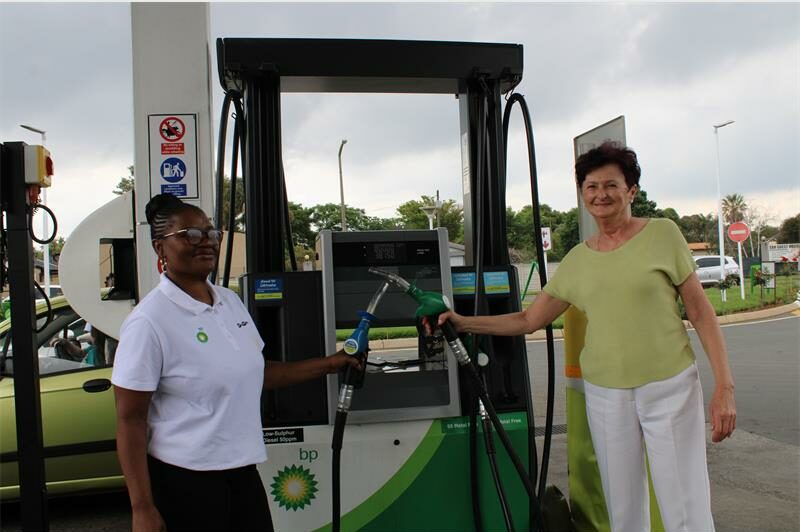 A black woman and a white woman standing at petrol pump with the BP logo