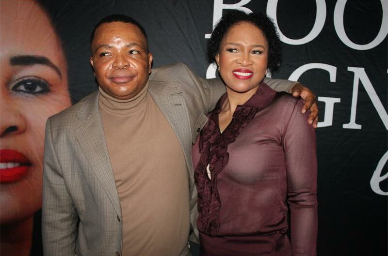 Black man with his arm around a black woman