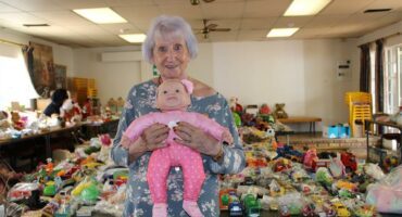 Woman with grey hair holding a doll