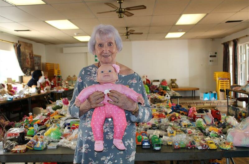 Woman with grey hair holding a doll