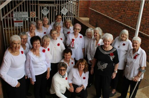 A group of 20 women with one holding a lit candle