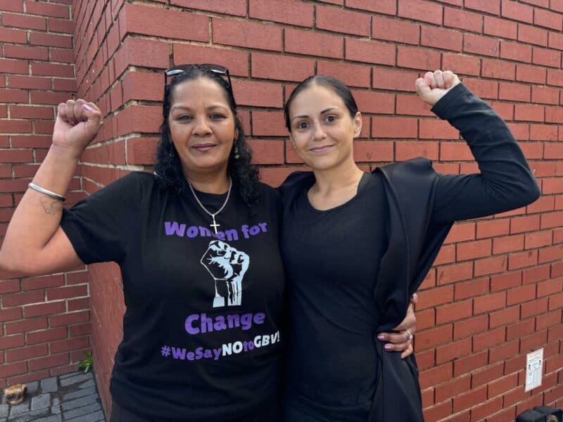 Photo of two women wearing black.