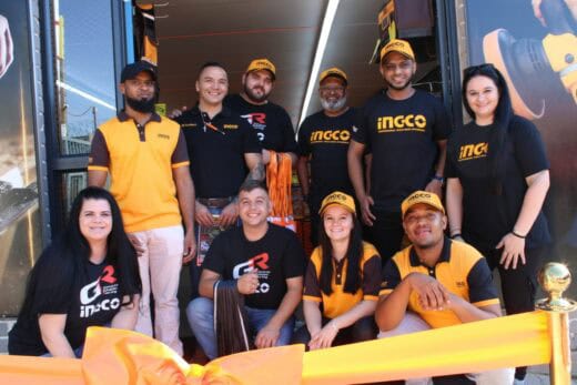 Group of people standing behind an orange ribbon