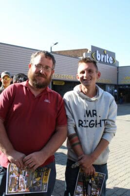Two men standing outside a shot