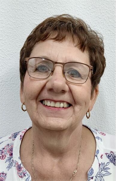 White woman with glasses and short hair.