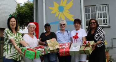 Group of women holding Christmas gifts